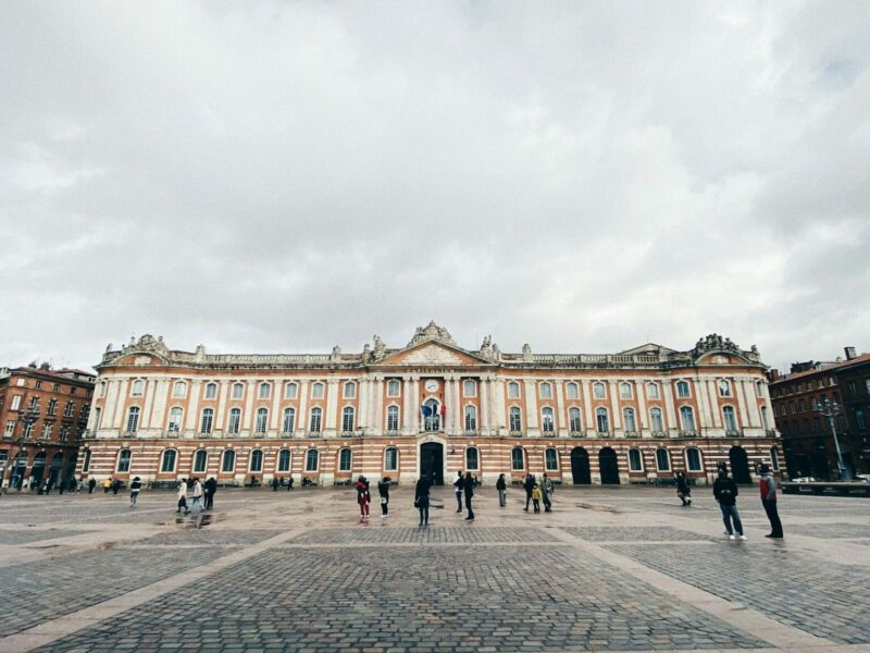 Façade en brique rose et place piétonne dans le centre historique de Toulouse – secteur d’intervention de notre peintre en bâtiment