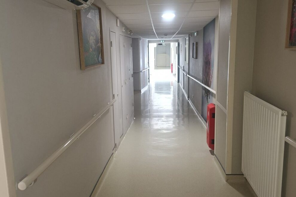 Couloir d'un établissement d'accueil repeint, mains courantes et radiateurs