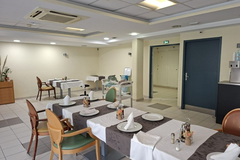 Salle de restaurant d'un établissement d'accueil repeinte en tons clairs