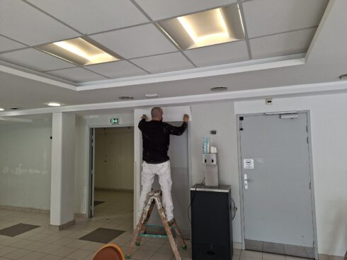 Peintre d'AB Peinture repeignant un encadrement de porte