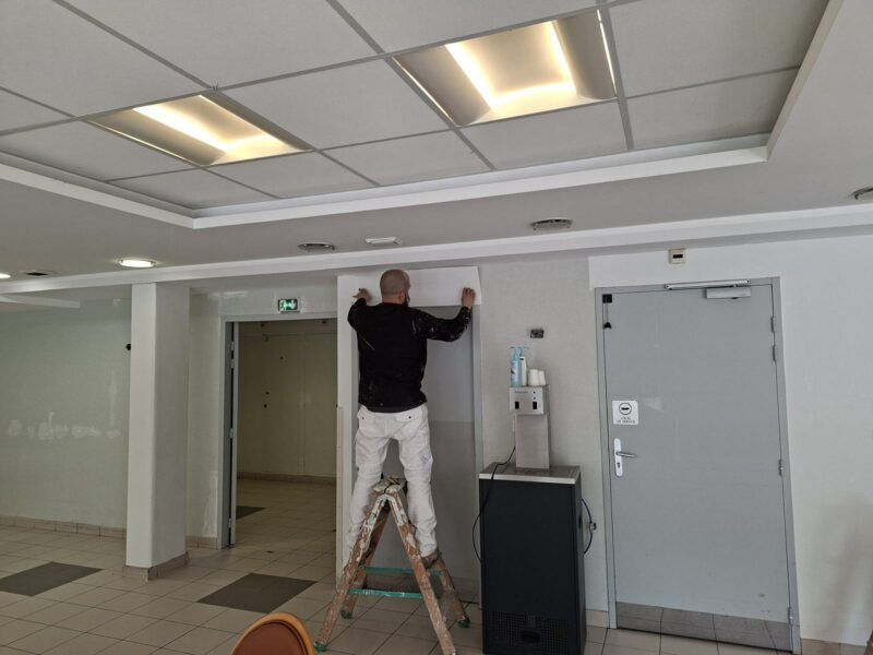 Peintre d'AB Peinture repeignant un encadrement de porte