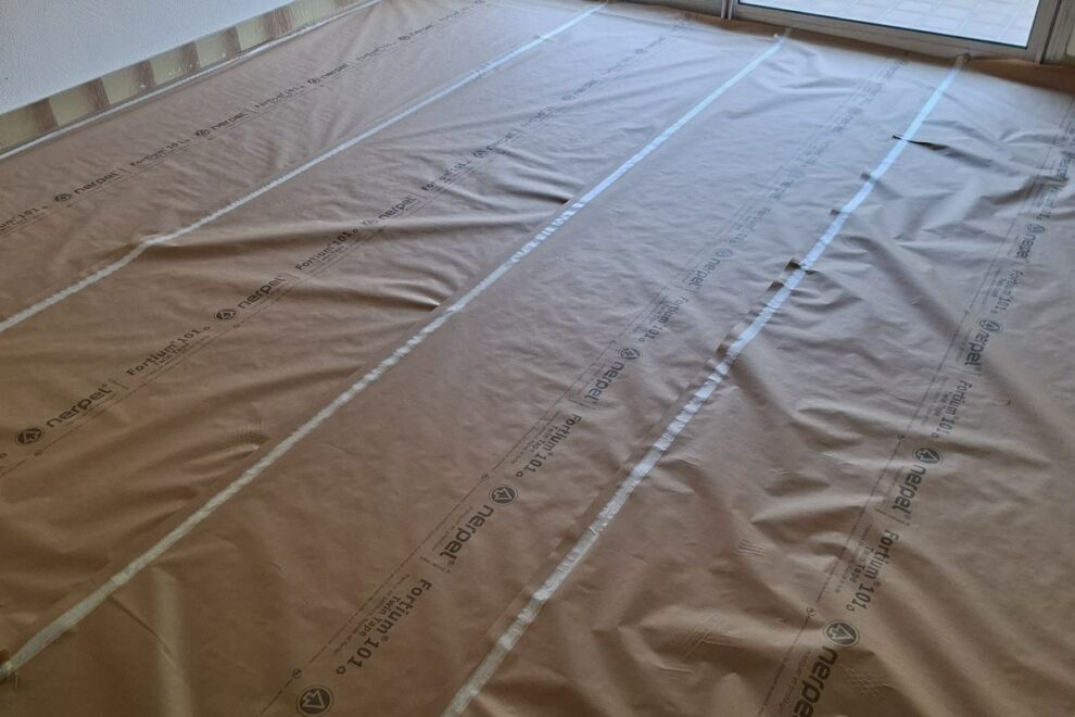 Sol d'un séjour entièrement protégé par du papier de protection avant peinture