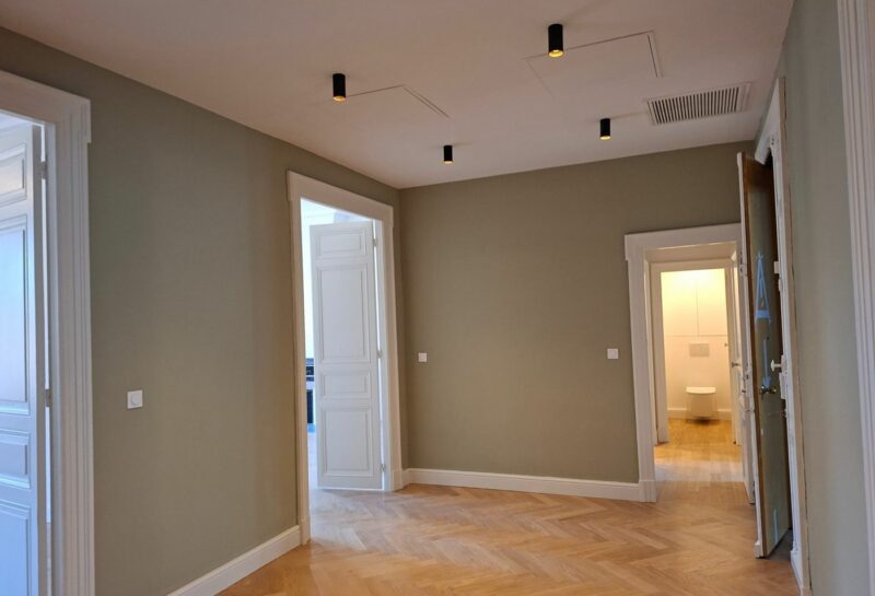 Entrée d'appartement peinte en vert sauge avec portes et encadrements blancs, réalisée par AB Peinture