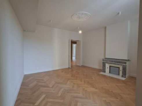 Pièce avec rosace au plafond et cheminée en marbre gris, murs blancs