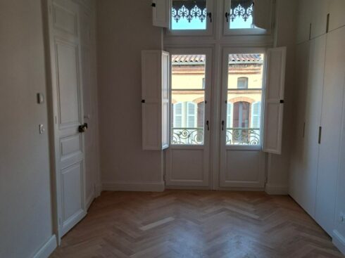 Chambre avec porte-fenêtre, volets intérieurs et placard, murs clairs