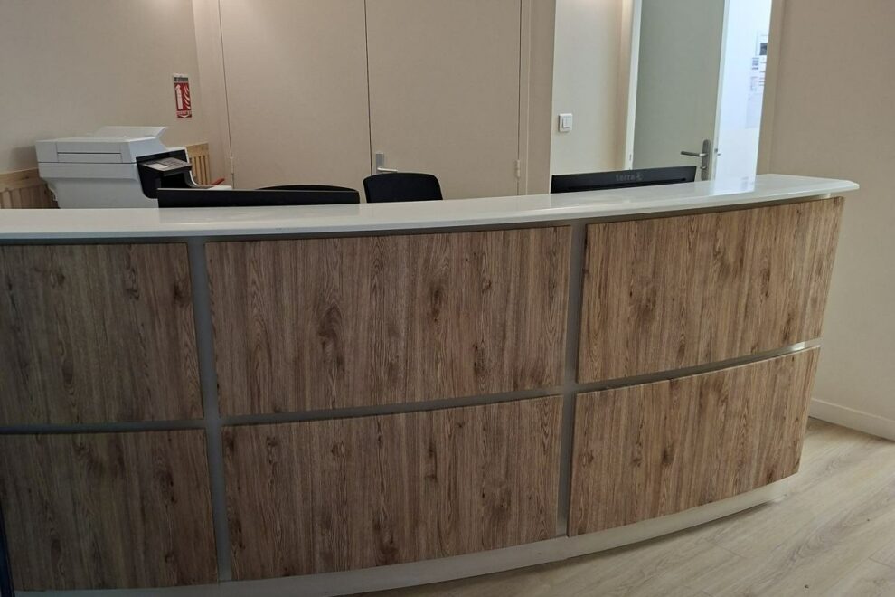 Banque d'accueil d'un cabinet rénovée avec un habillage effet bois