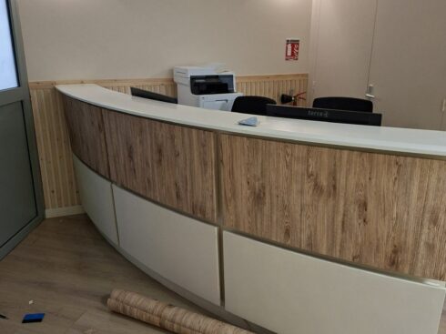Pose de l'adhésif décoratif effet bois sur la banque d'accueil