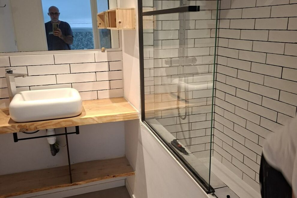 Salle de bain rénovée : vasque sur plan en bois, carrelage métro et paroi de douche