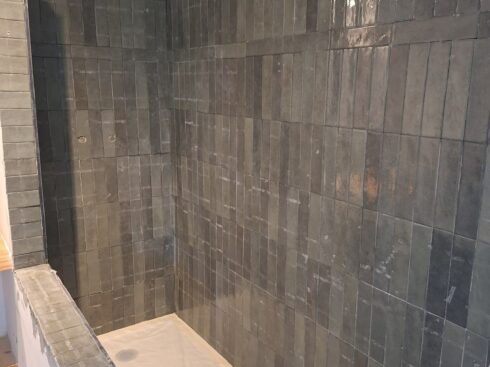 Mur de douche en carreaux verts posé pendant la rénovation
