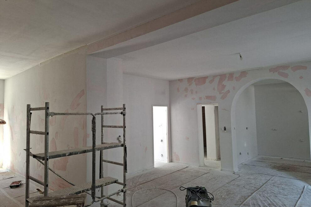 Séjour d'une maison ancienne en cours de rénovation, murs enduits et échafaudage